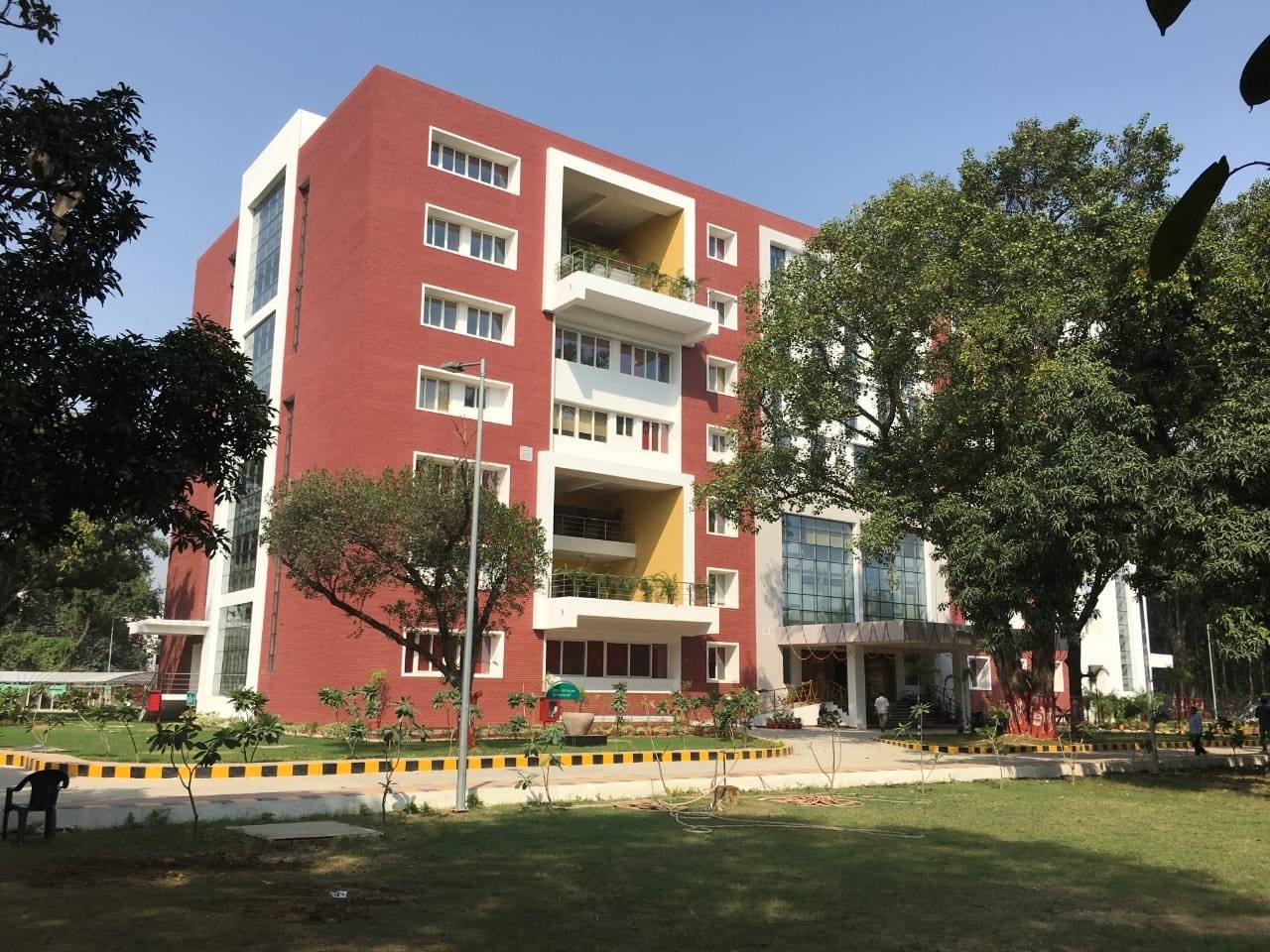 The side wing, seen across the lawn among mature trees