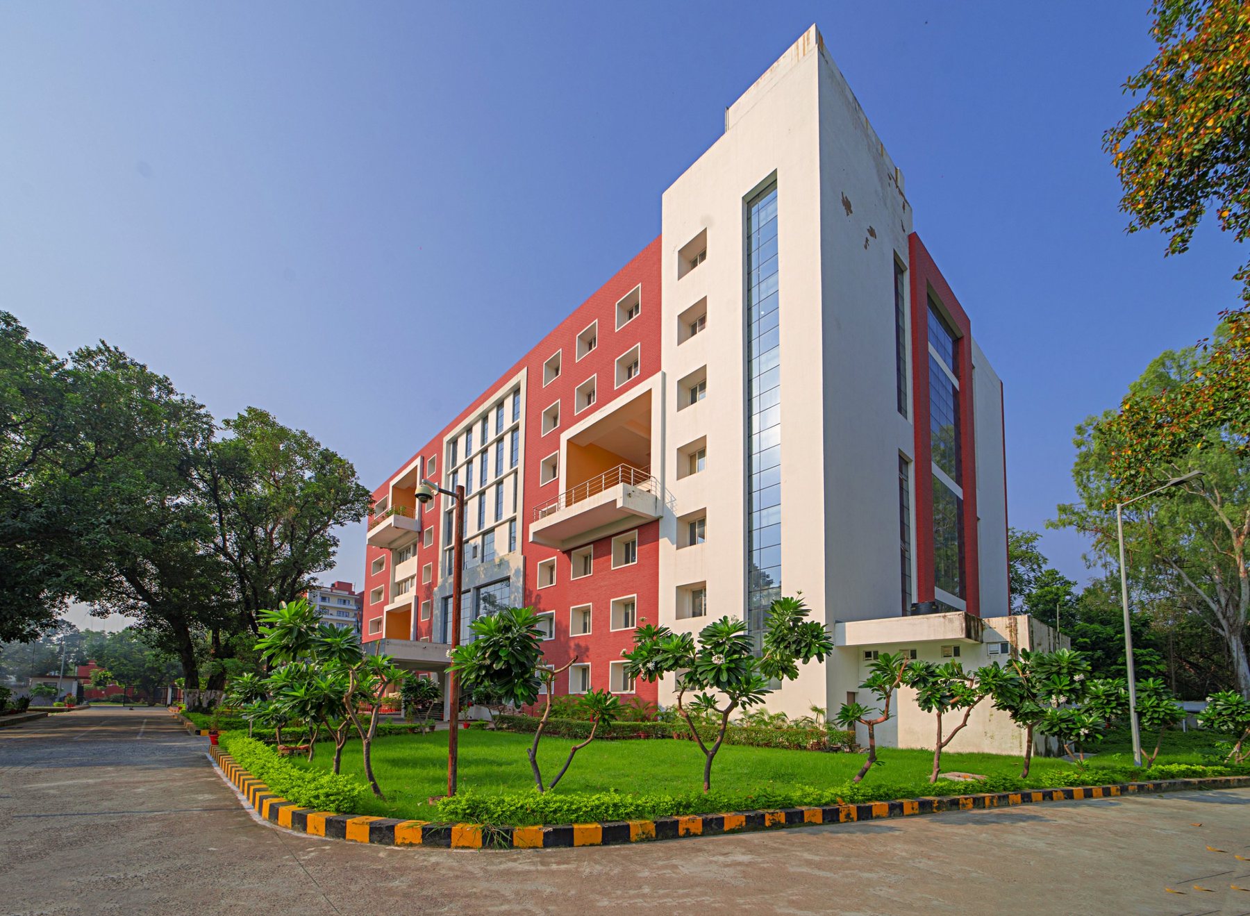 The white stair tower and red-brick wings, set in planting